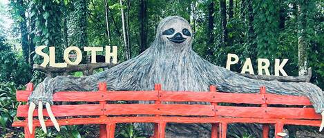 A sloth-themed bench with the words "Sloth Park" in the background.