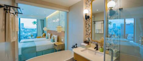A modern bathroom with a bathtub, a large mirror, and a view of the city.