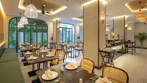 A restaurant with multiple dining tables, chairs, and a buffet area.