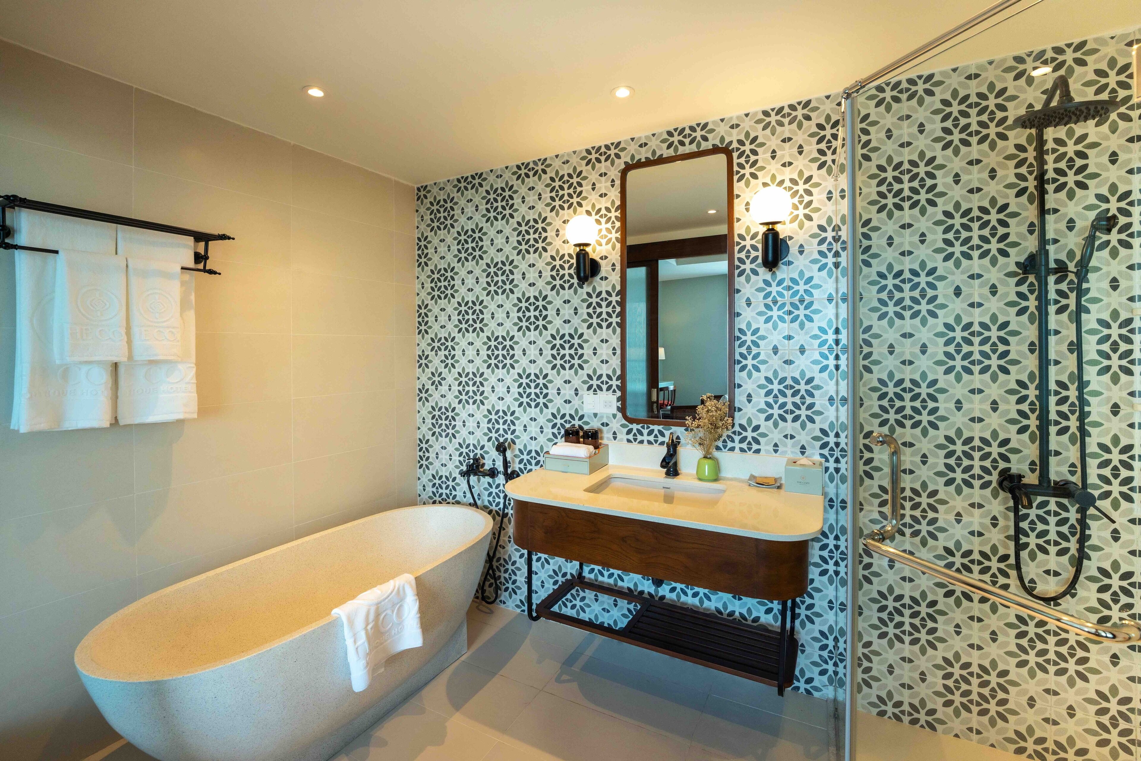 A modern bathroom with a freestanding bathtub, a vanity with a mirror, and a shower area.