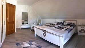 Ein Schlafzimmer mit Bett, Nachttisch, Stuhl und Spiegel.