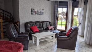 Un salon comprenant un canapé, une table basse et un tableau accroché au mur.