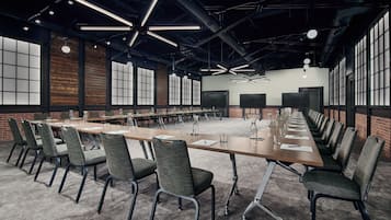Une salle de conférence dotée d’une longue table, de chaises et d’un plafond au design moderne.