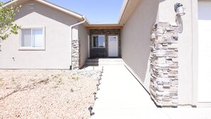 A residential building with a stone facade, a front door, and a clear sky. - Perfect family friendly Home Base for your Red Rock adventures (Kanab)