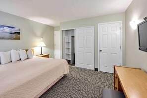 A hotel room with a bed, a desk, a lamp, a TV, and a closet. - Oceanfront Suite - Beach Access - Heated Pool and Hot Tub! (Lincoln City)