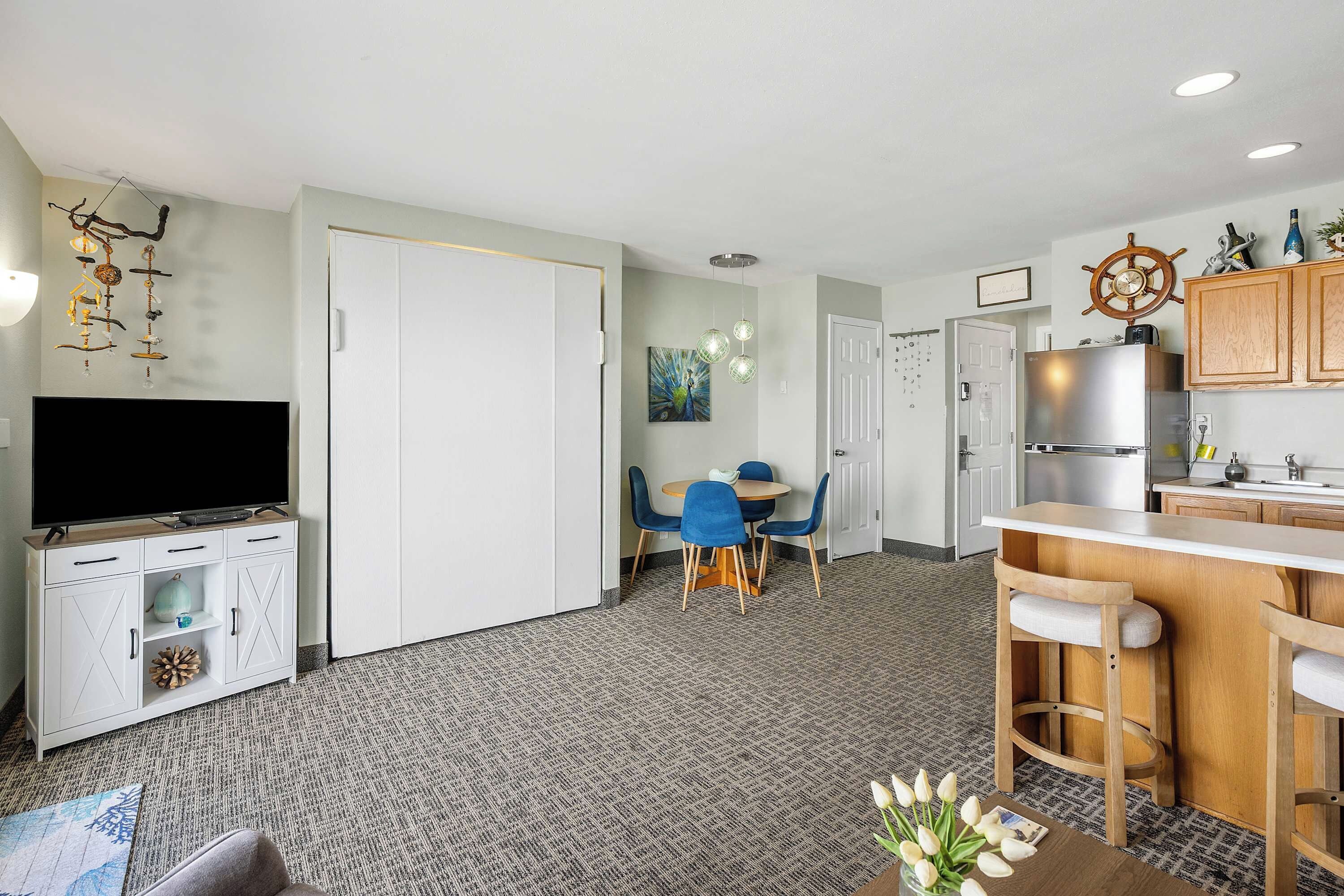 A modern apartment with a living room, dining area, and kitchen.