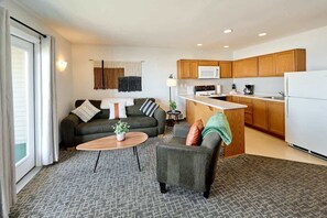 A modern apartment with a living room, kitchen, and dining area.