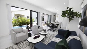 Un salon moderne comprenant un canapé, une table basse et un coin repas avec une table et des chaises.