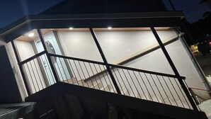 Un bâtiment doté d’un escalier menant à un étage supérieur, l’ensemble étant entouré d’une rambarde en métal.