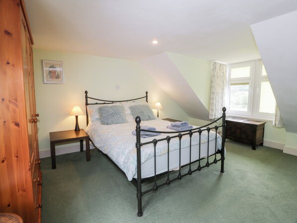 Une chambre à coucher avec un lit à baldaquin, deux tables de chevet, une commode, une armoire en bois et une fenêtre avec des rideaux.