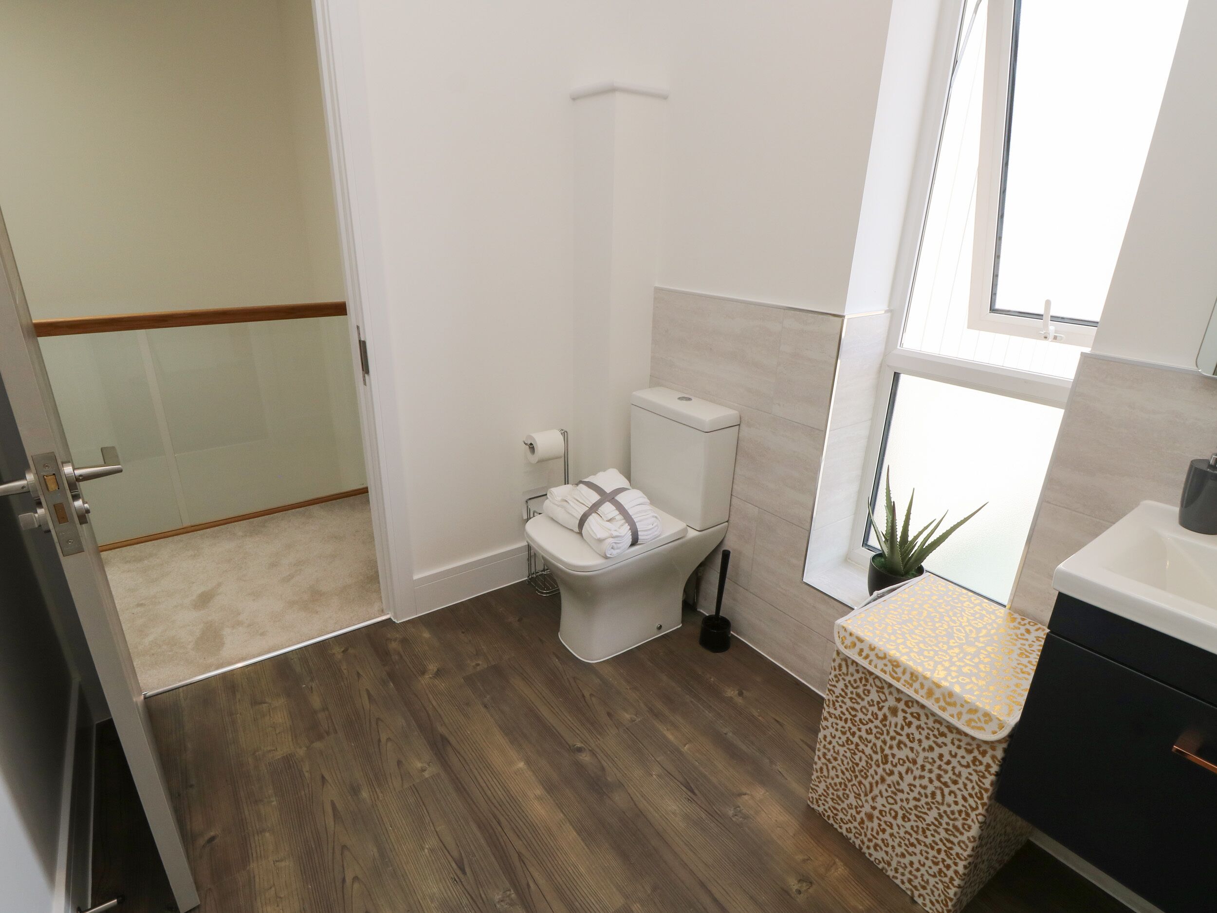 Un baño con inodoro, lavabo y ventana.