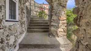 A stone staircase leading up to a window with a metal railing. - Blueberry - Charming apartment, with panoramic terrace with a view over Levanto (Montale)
