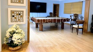 A spacious room with a pool table, a television mounted on the wall, and a dining area with chairs and a table. - PARADISE VILLA  CHEF+FOOD GOLF POOL BBQ KING BEDS (Juan Dolio)