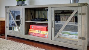 A wooden cabinet with glass doors containing board games and a small plant on top. - Spacious Family Retreat near Botanica, Legoland, Frontwave Arena, & Beach! (Oceanside)