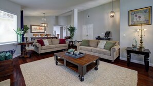 A spacious living room with two sofas, a coffee table, and a dining table. - Spacious Family Retreat near Botanica, Legoland, Frontwave Arena, & Beach! (Oceanside)