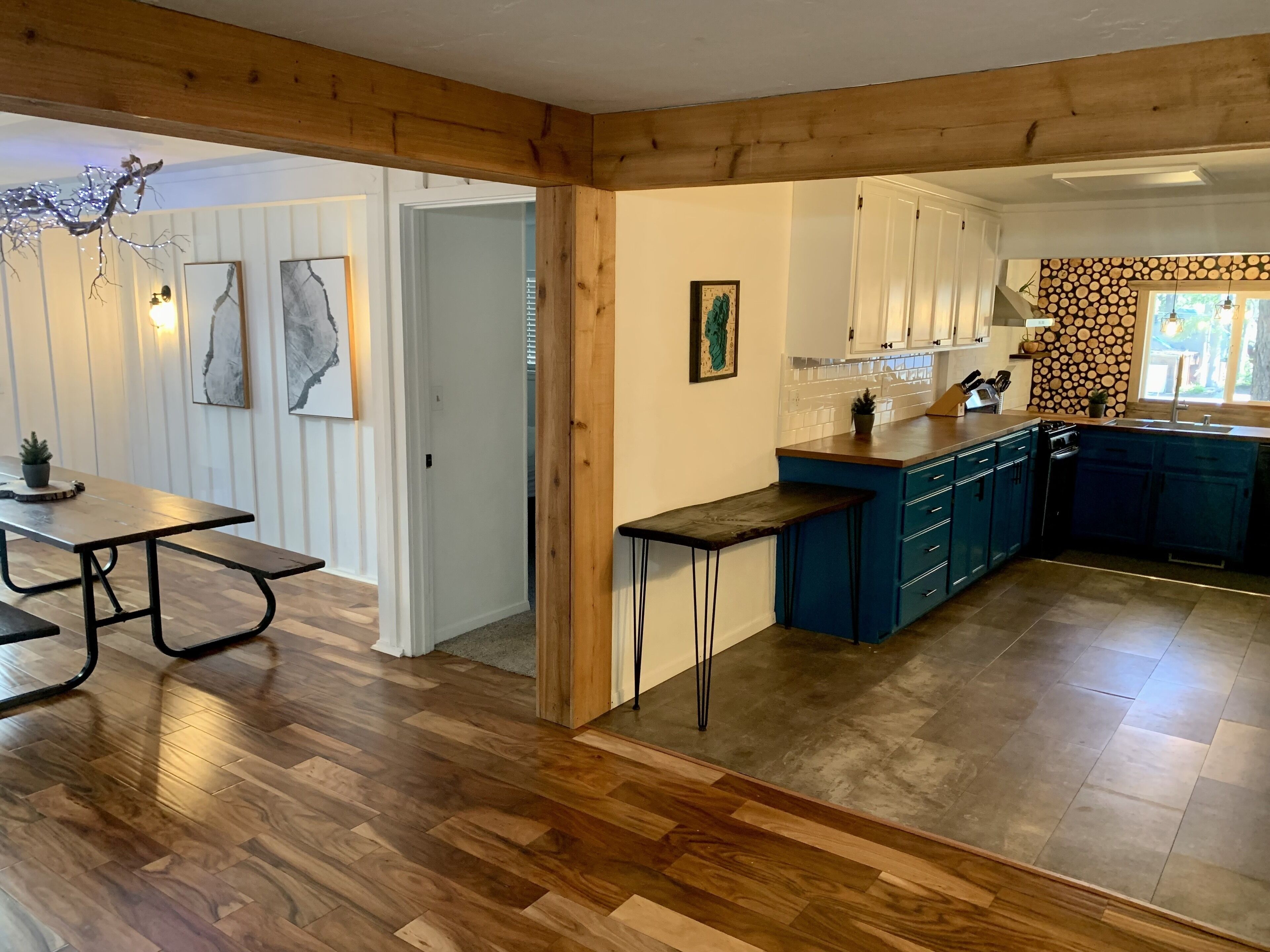Una cocina moderna con armarios azules, un banco de madera y una mesa de comedor con banco.