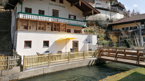 A two-story building with a balcony and a yellow umbrella. - Vacation home Villa klein Venedig, 60sqm, 2 bedrooms, balcony, terrace, WLAN (Siegsdorf)