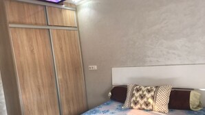 Ein Schlafzimmer mit Bett, Kleiderschrank und Kopfteil.