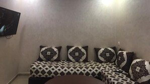 Ein Zimmer mit einem gewölbten Bett, gemusterten Kissen und einer Decke mit LED-Beleuchtung.
