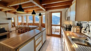 A spacious kitchen with wooden cabinets, a central island, and a view of the mountains.