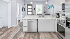 A modern kitchen with white cabinetry, a dishwasher, a sink, and a stove. - 1st Floor Condo No Steps - 2 miles to Downtown (Nashville)