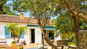 A wooden deck with lounge chairs, a small table with a bottle and glass, and a swimming pool. - Villa with private pool 🌿 3 bedrooms - near beaches & center - absolute calm (Cavalaire-sur-Mer)