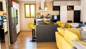 A modern kitchen with a central island, a dining area with yellow chairs, and a living room with a sofa. - Villa with private pool 🌿 3 bedrooms - near beaches & center - absolute calm (Cavalaire-sur-Mer)