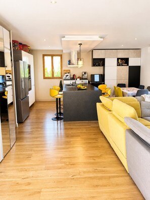 A modern kitchen with a central island, a dining area with yellow chairs, and a living room with a sofa. - Villa with private pool 🌿 3 bedrooms - near beaches & center - absolute calm (Cavalaire-sur-Mer)
