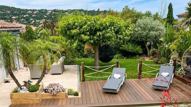 A pool with wooden deck, lounge chairs, and a garden with various plants. - Villa with private pool 🌿 3 bedrooms - near beaches & center - absolute calm (Cavalaire-sur-Mer)