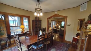 A dining area with a wooden table and chairs, a patterned rug, and a chandelier. - Historic Stonehouse on Main St. Walking distance to shops, restaurant the River. (Hardy)