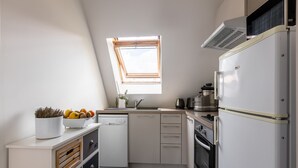 Cuina compacta amb rentaplats, forn i finestra sobre la pica.
