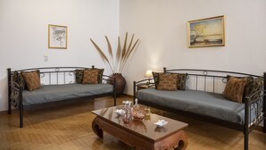 A living room with two sofas, a coffee table, and a painting on the wall. - Cycladic Sea view Mansion near the Castle (Νάξος)