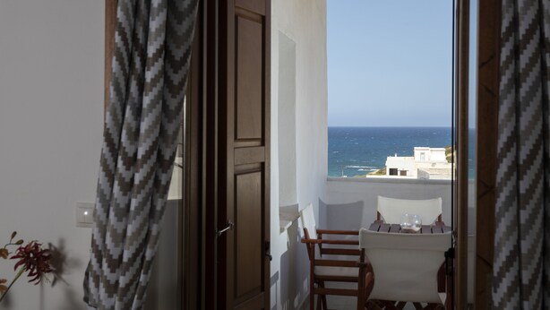 A balcony with a view of the sea, a table with a glass, and a chair. - Cycladic Sea view Mansion near the Castle (Νάξος)