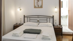 A bedroom with a bed, bedside lamps, a framed picture on the wall, and a wooden ceiling. - Cycladic Sea view Mansion near the Castle (Νάξος)