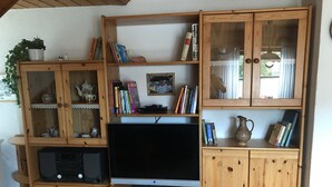 Ein Holz-Entertainment-Möbelstück mit Fernseher, Büchern und Dekorationselementen.