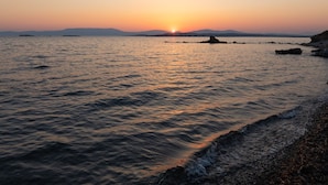 Une plage aux eaux calmes, où l’on peut admirer le coucher du soleil.
