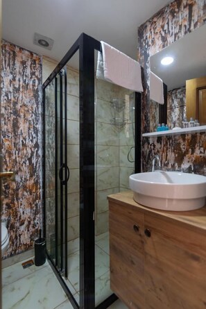 Douche, articles de toilette (gratuits), pantoufles, serviettes fournies