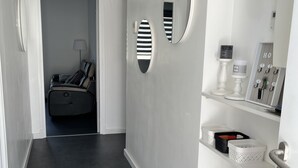 A modern hallway with a dark floor, a bed in the background, and a wall-mounted mirror. - Superb upstairs villa with private garden and parking. (Saint-laurent-du-var)