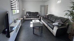A modern living room with a sofa, a coffee table, and a television. - Superb upstairs villa with private garden and parking. (Saint-laurent-du-var)