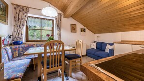 A cozy room with a wooden ceiling, a dining table with chairs, a sofa, and a ping pong table. - Holiday Apartment "Waldesruh" with Mountain View, Balcony & Wi-Fi (Mühlbach)