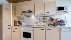 Een keuken met een fornuis, oven, magnetron en vaatwasser.
