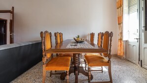 A dining area with a wooden table, chairs, and a bowl of fruit. - Holiday Home Villetta Luisa with Mountain View & Terraces (Villa San Pietro)