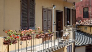 A balcony with potted plants, a door, and a window with shutters. - GuestHost - Cozy, completely renovated 47sqm apartment located on the 3rd floor of a building WITHOUT elevator. The apartment is accessed via an external balcony overlooking the quiet internal courtyard.The accommodation is located in an excellent locati (Como)