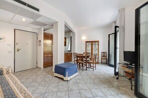 Une chambre d’hôtel comprenant un lit, une table à manger avec des chaises, un téléviseur et une porte-fenêtre coulissante.
