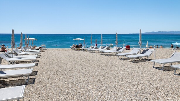 A beach with sun loungers and umbrellas, a clear sky, and the sea. - Pet-Friendly Apartment "18 Mehari" with Balcony & Wi-Fi (Varigotti)