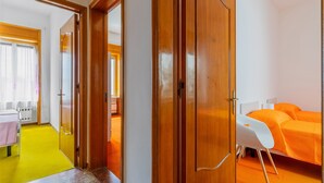 A hotel room with a bed, a desk, and a chair. There is a door leading to another room. - Apartment Casa LILLI 11 posti Near the Sea with Sea View, A/C & Balcony (santa maria al bagno)