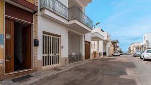 A residential street with houses, a gated entrance, and parked cars. - Apartment Casa LILLI 11 posti Near the Sea with Sea View, A/C & Balcony (santa maria al bagno)