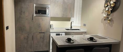 A modern kitchen with a central island, built-in appliances, and a decorative wall piece.