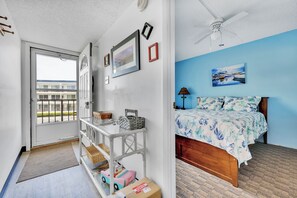 Enjoy a comfortable stay with a neatly arranged bed, large window, and functional ceiling fan.