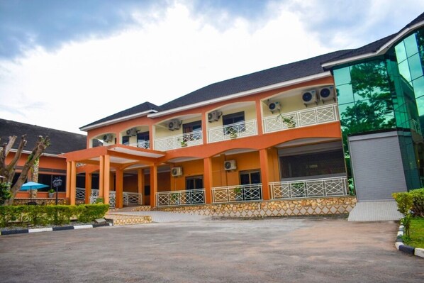A multi-story building with a covered entrance, air conditioning units, and a balcony. - ROCK CLASSIC HOTEL LIMITED (Tororo)